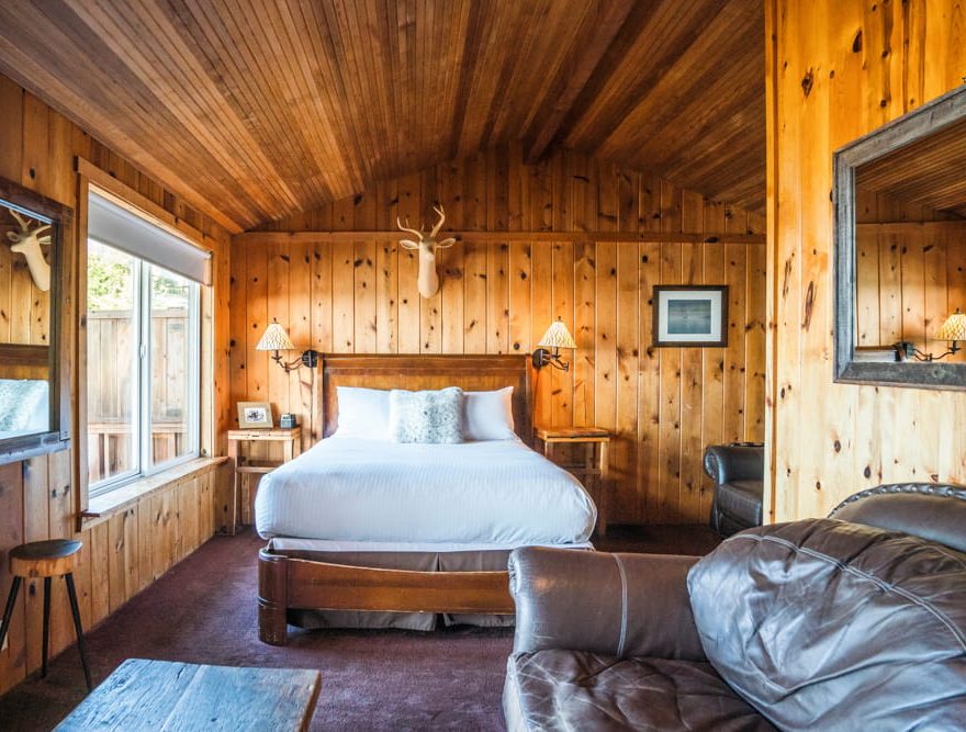 Queen bed in a cabin with a leather couch
